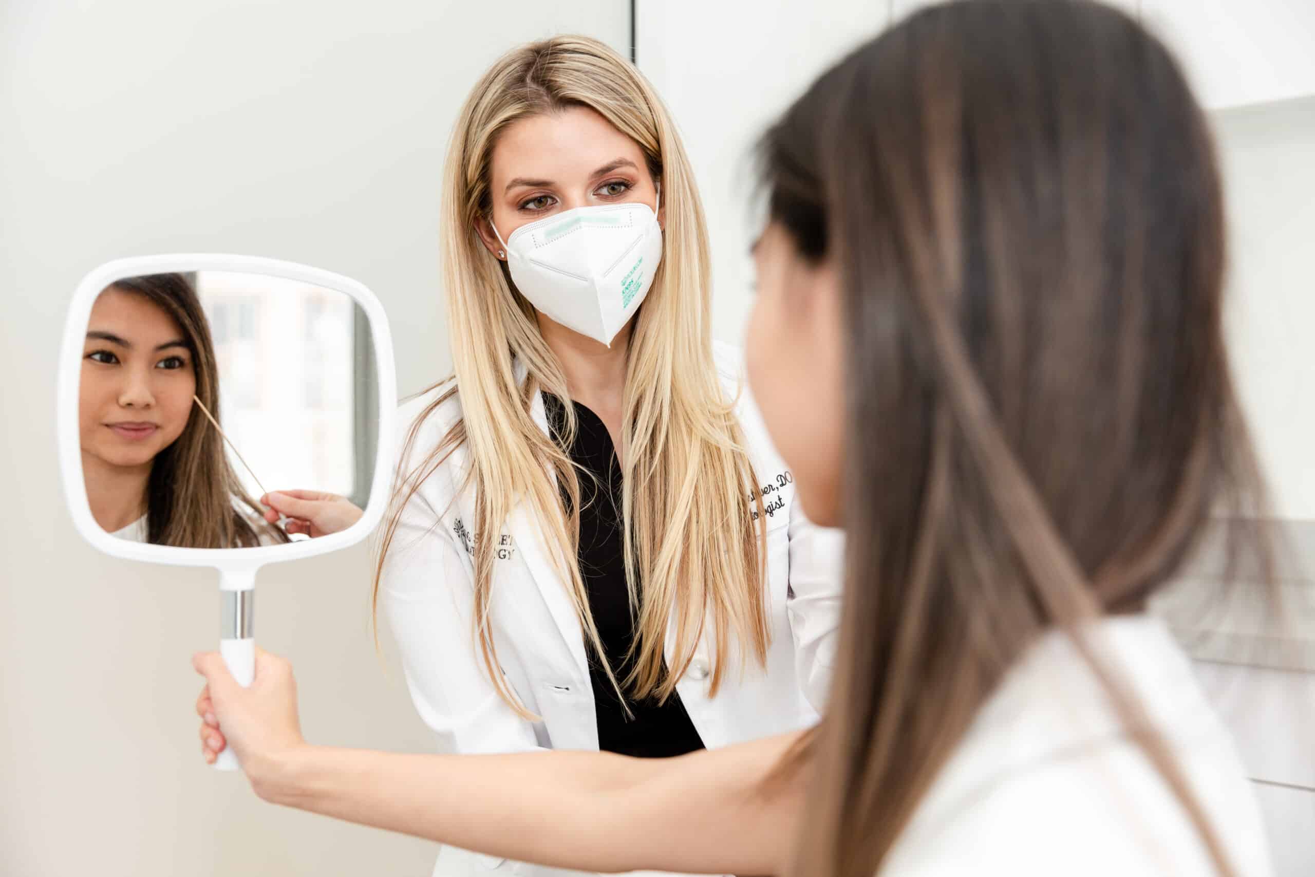 dermatologist with a patient looking in the mirror at their botox treatment results in NYC, NY