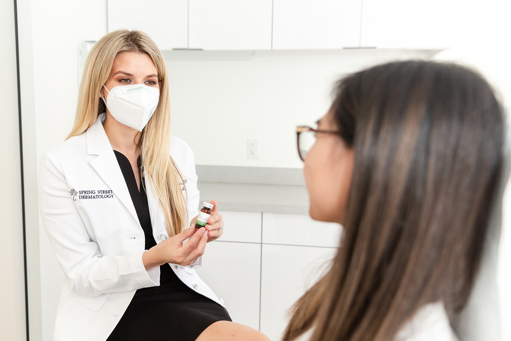 Dermatologist recommending skin care products to a young woman patient in New York City, NY. 