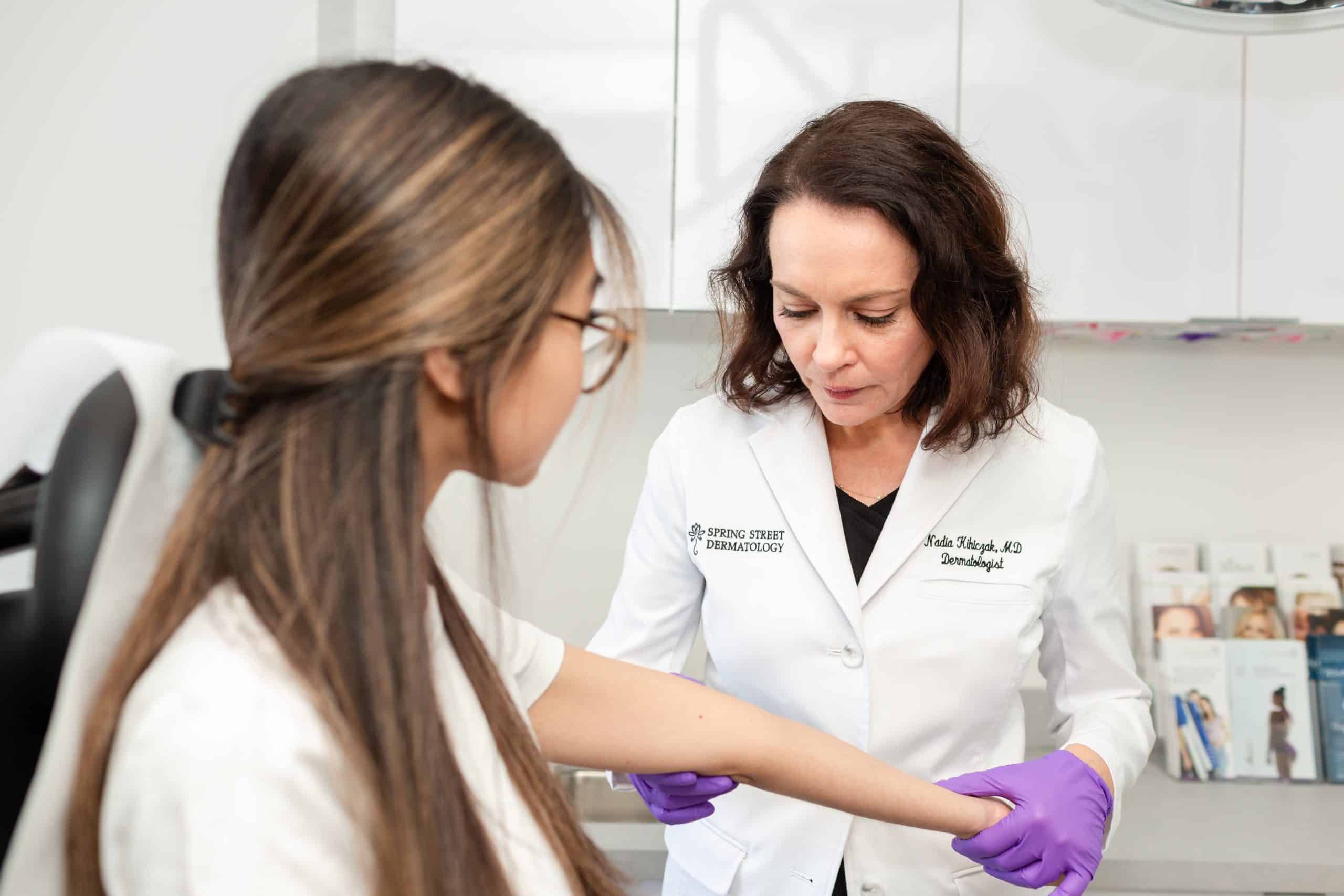 Doctor examines patient for sun damage in New York City